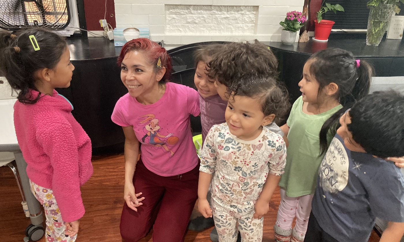 Provider with children gathered in the child care setting