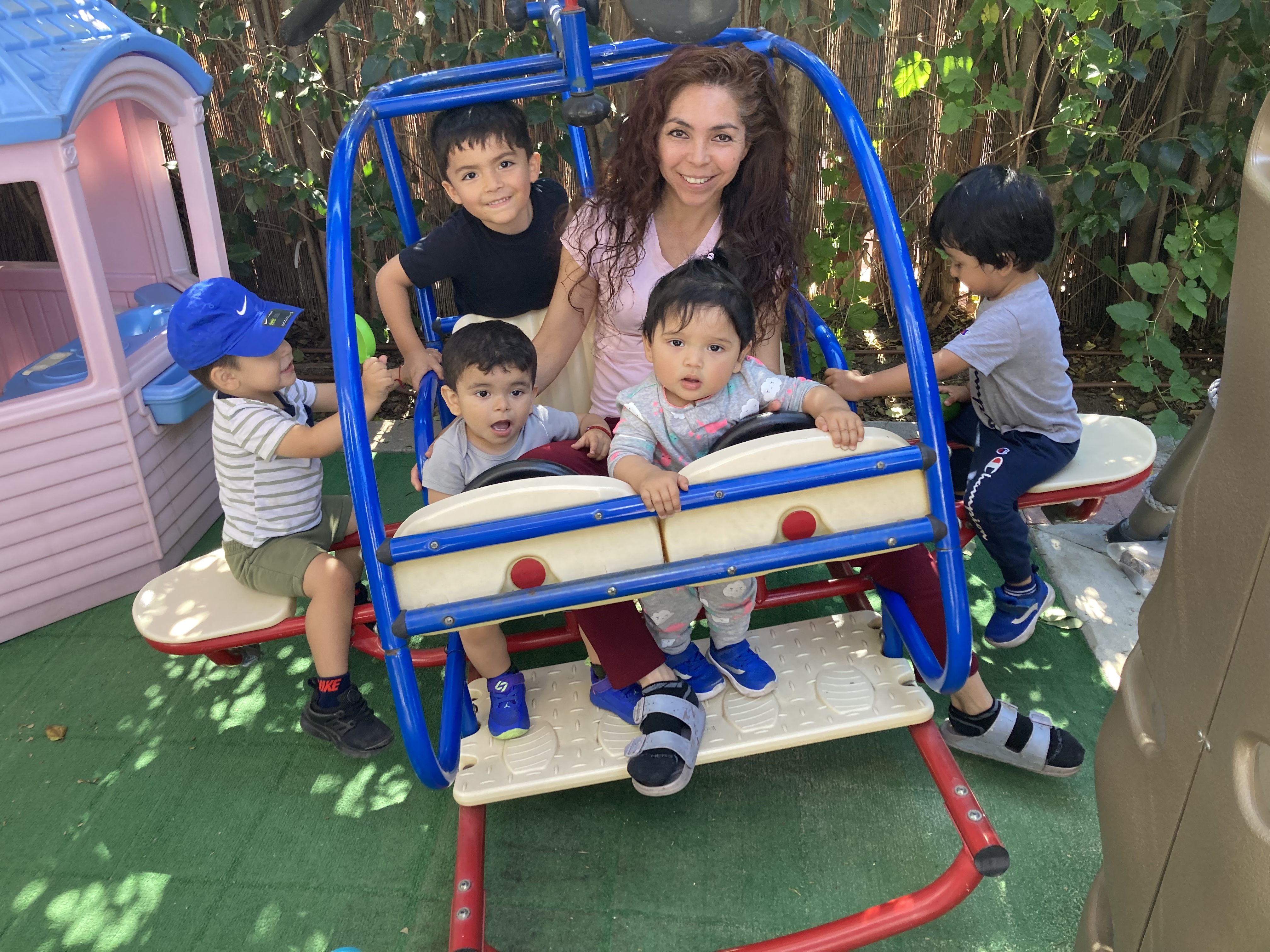 Provider smiling with children in an outdoor play area